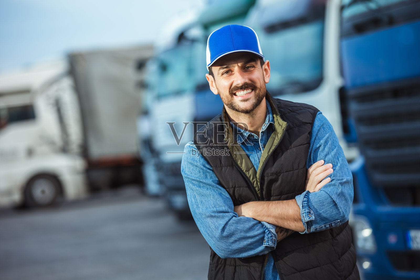 快乐自信的男司机站在他的卡车前。照片摄影图片