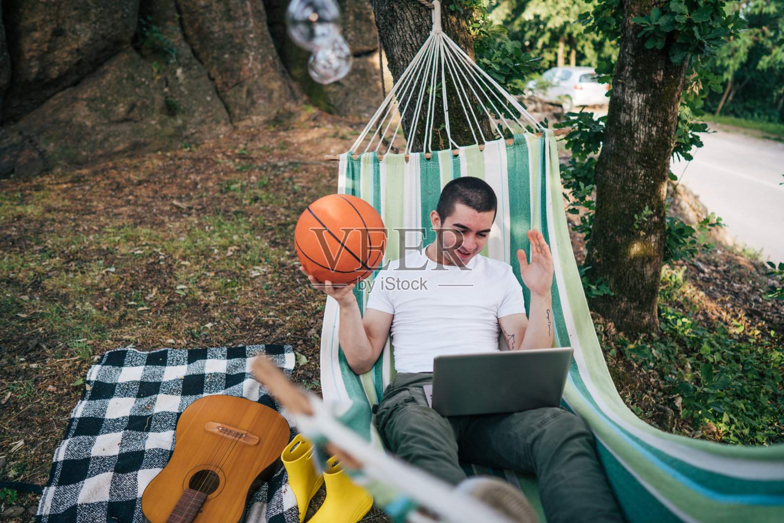 年轻人躺在电脑上看篮球比赛照片摄影图片