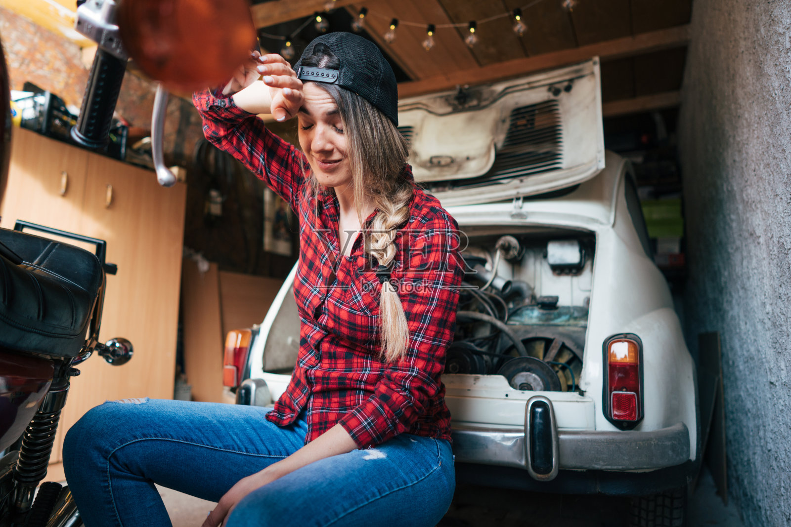 年轻女子修理老式摩托车照片摄影图片