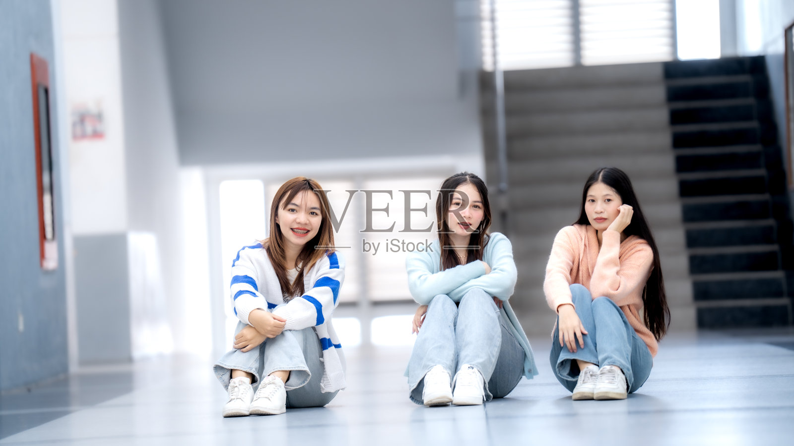 三个女人坐在走廊的地板上照片摄影图片