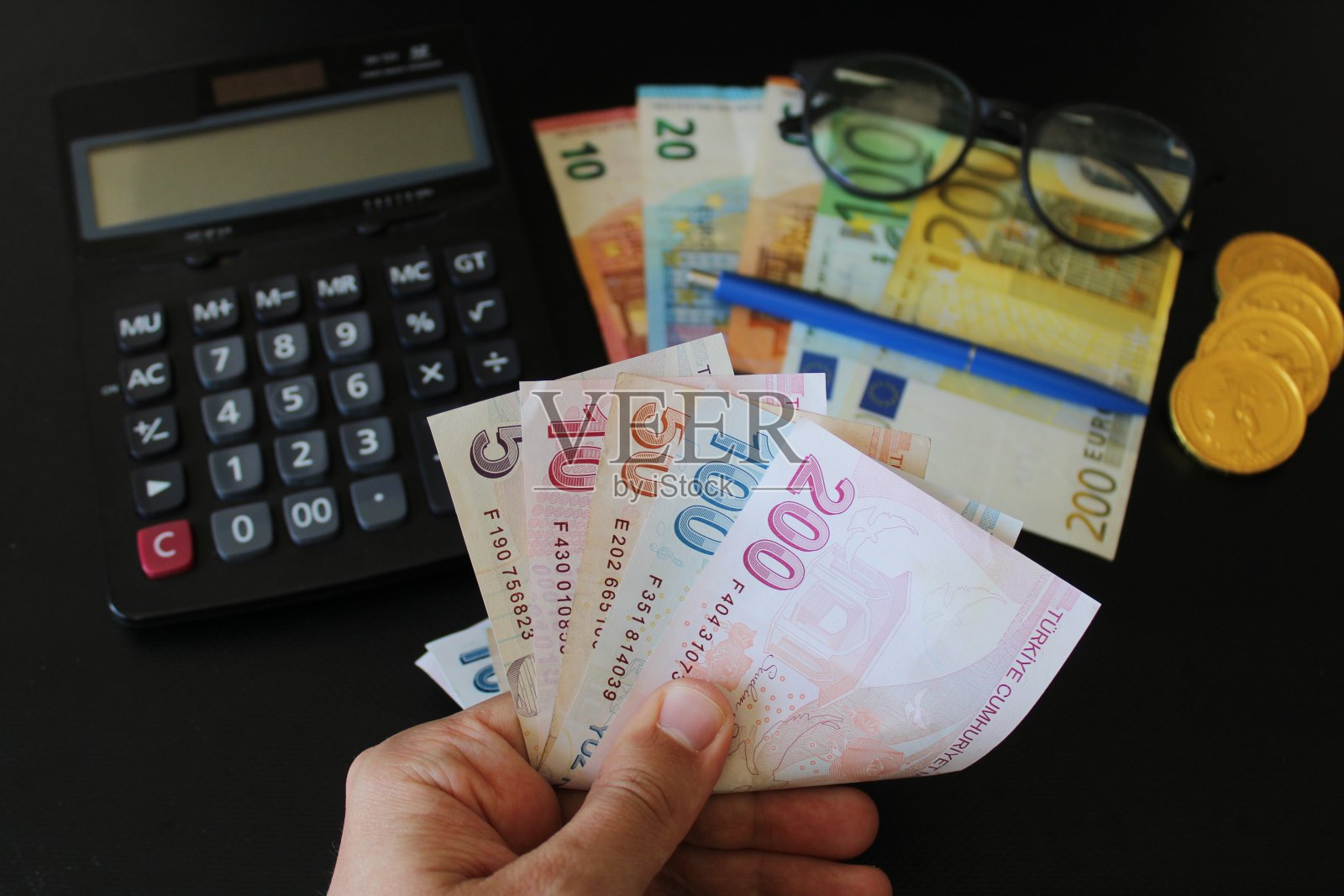 土耳其的纸币。计算器在后台。土耳其里拉钞票。一个人用手数着土耳其的钱。照片摄影图片