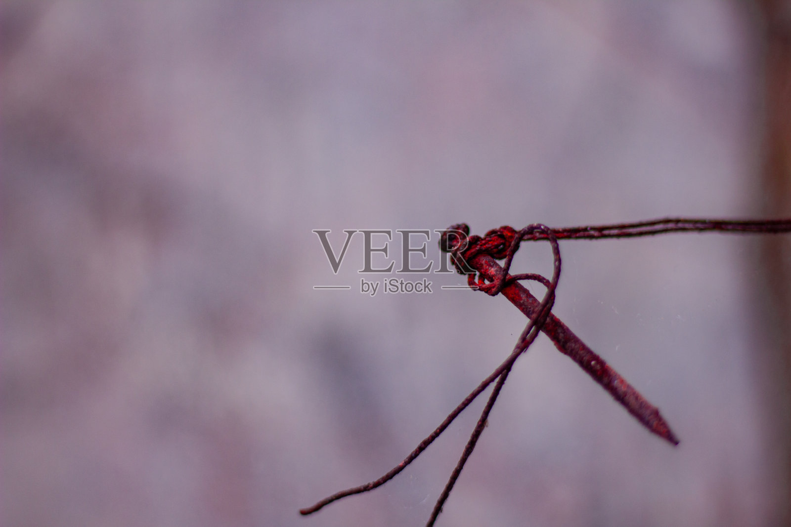 满是旧铁丝的生锈铁钉卡在墙上照片摄影图片