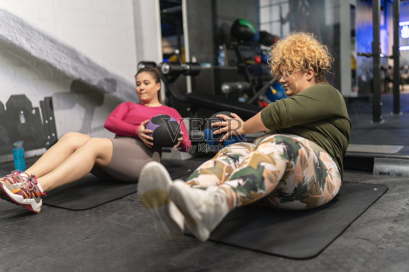 两个大码女性拥抱自己的身体,因为他们从事具有挑战性的锻炼照片摄影图片