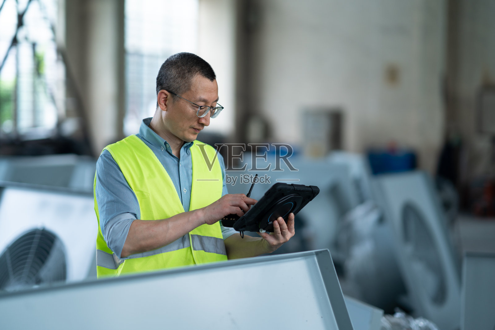 在车间与平板电脑一起工作的人照片摄影图片