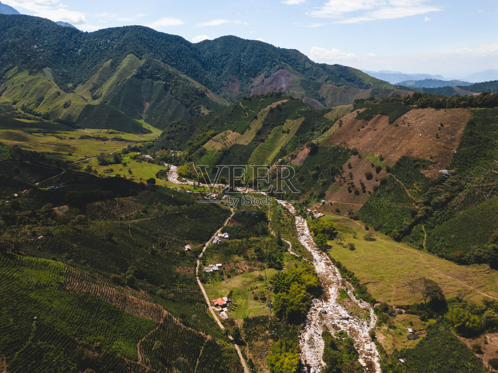 山谷中有一条河,周围环绕着青山照片摄影图片