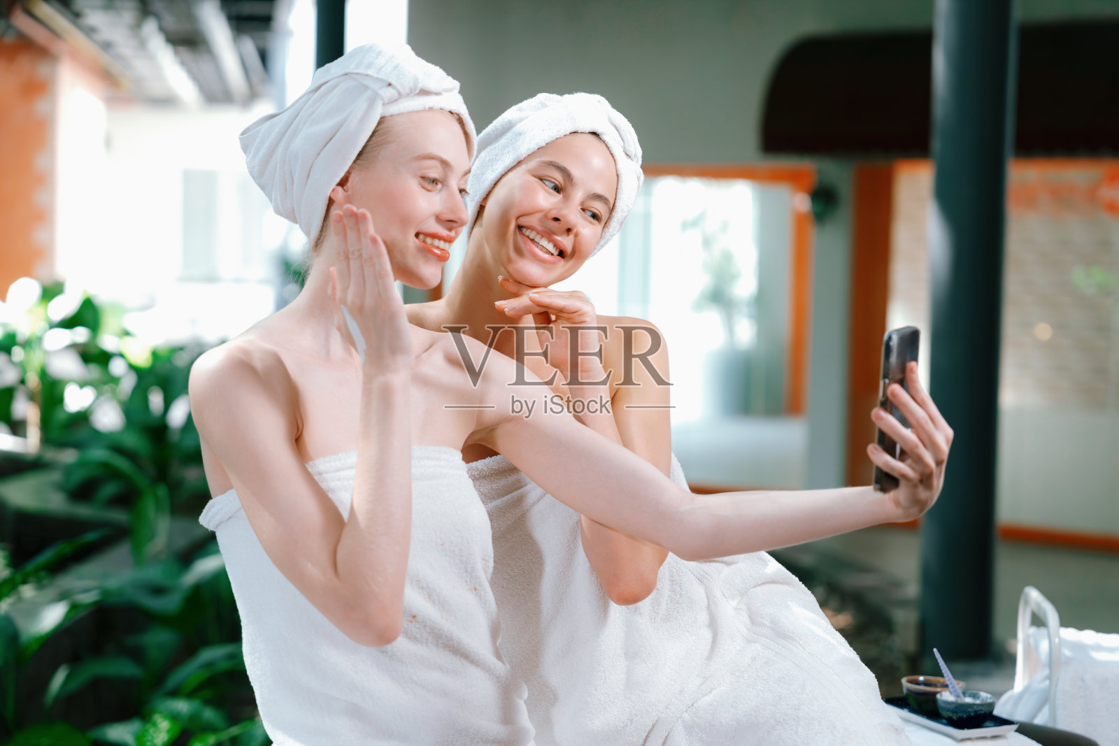 一对穿着白毛巾的美女在户外拍照。宁静。照片摄影图片