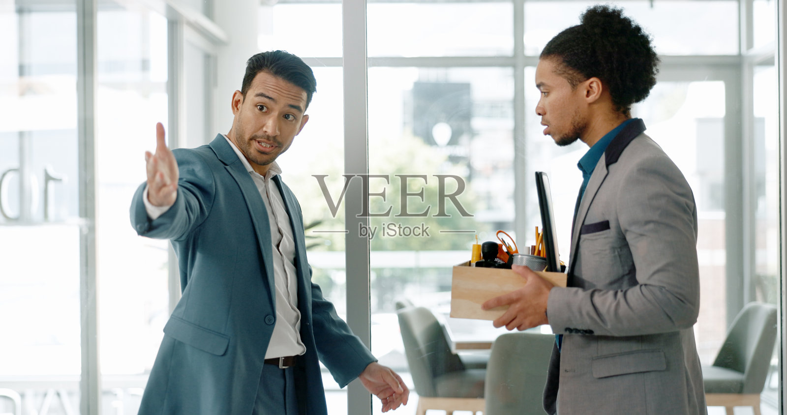 被解雇的纸板箱商人与愤怒的经理和员工在办公室里大打出手。在一家失败的公司,解雇,沮丧和工人离开与就业斗争照片摄影图片