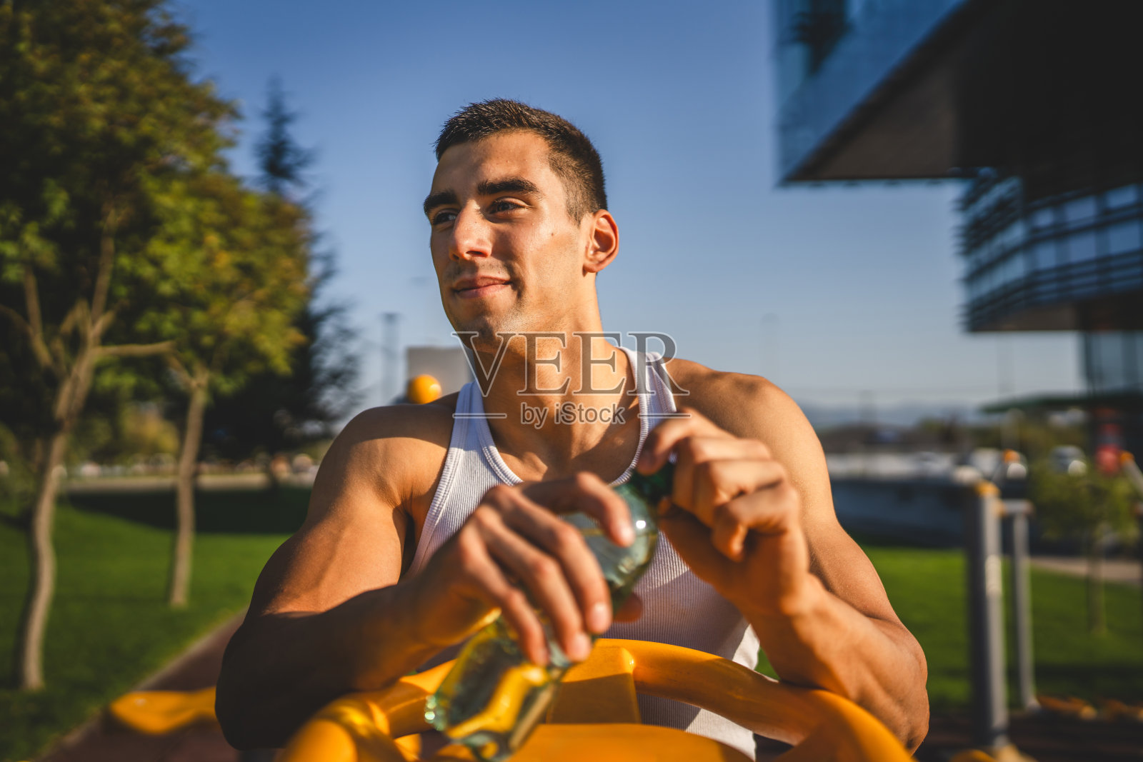 一名年轻的男运动员手持瓶装水在户外训练照片摄影图片