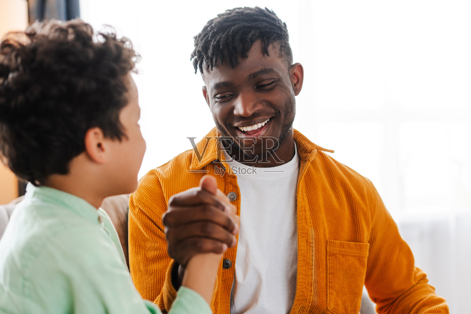 快乐的小男孩和他的非裔美国父亲在一起聊天照片摄影图片