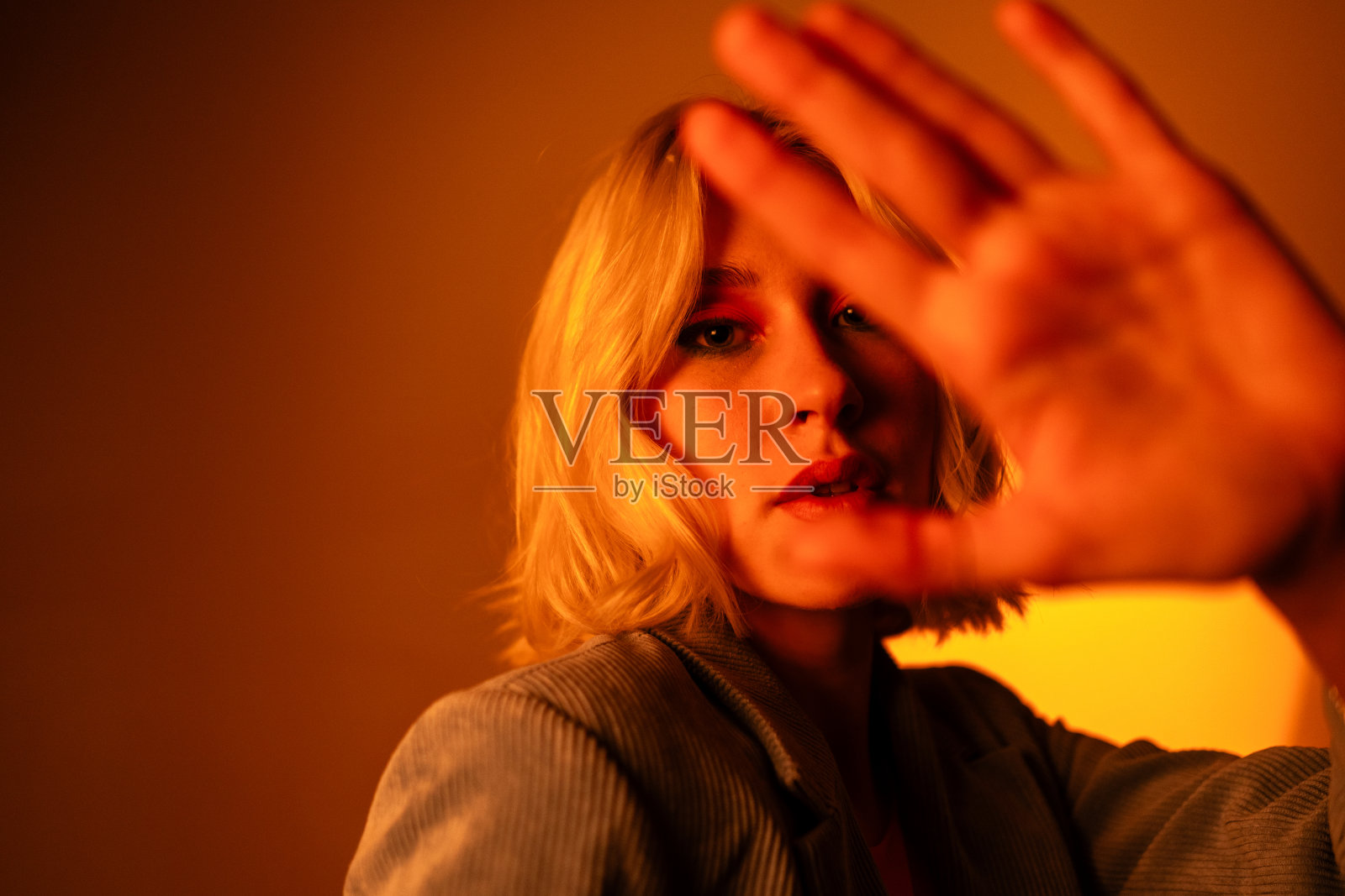 戴着时髦太阳镜的时髦女人,在橙色背景上摆姿势照片摄影图片