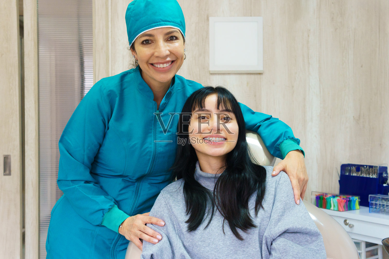 正畸医生和他的病人拥抱,微笑着看着镜头。照片摄影图片