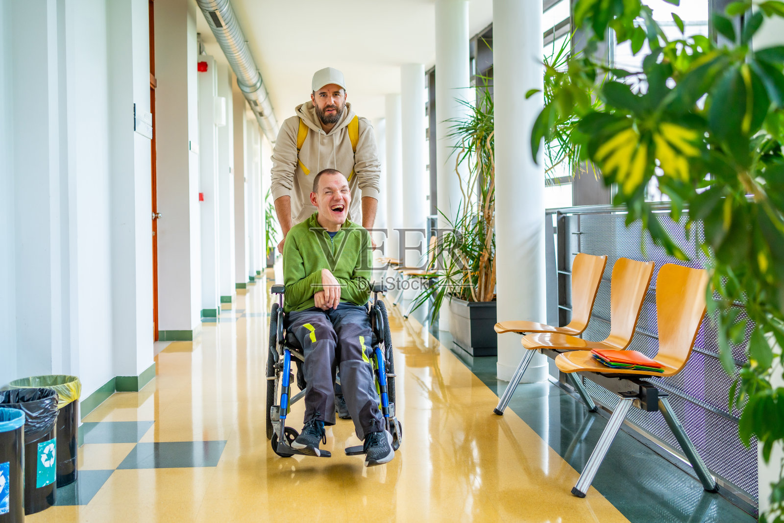 朋友帮助残疾人在大学里走动照片摄影图片