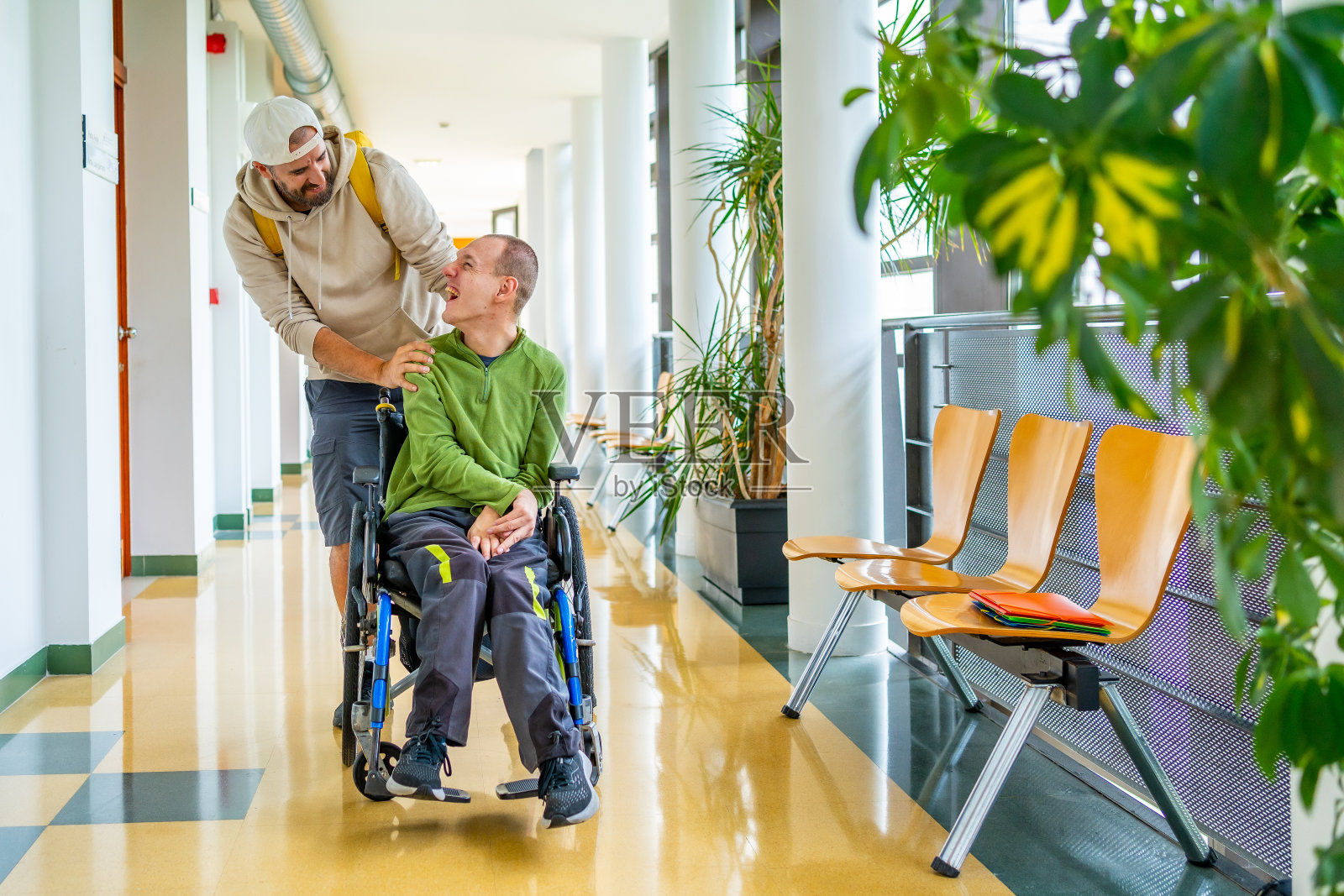 残疾人和朋友在大学走廊上散步照片摄影图片