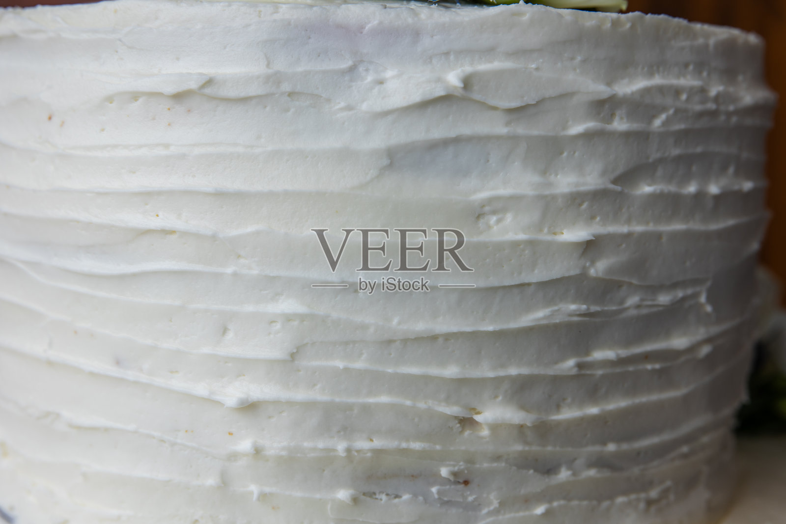 一张特写照片,一只白色质朴的手刮着婚礼蛋糕照片摄影图片