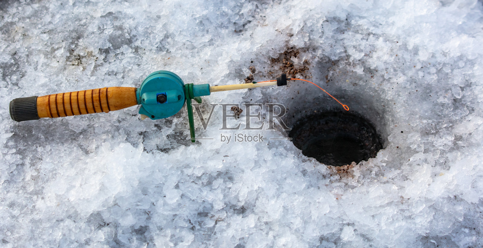 冬天鱼竿在冰上。冰上钓鱼照片摄影图片
