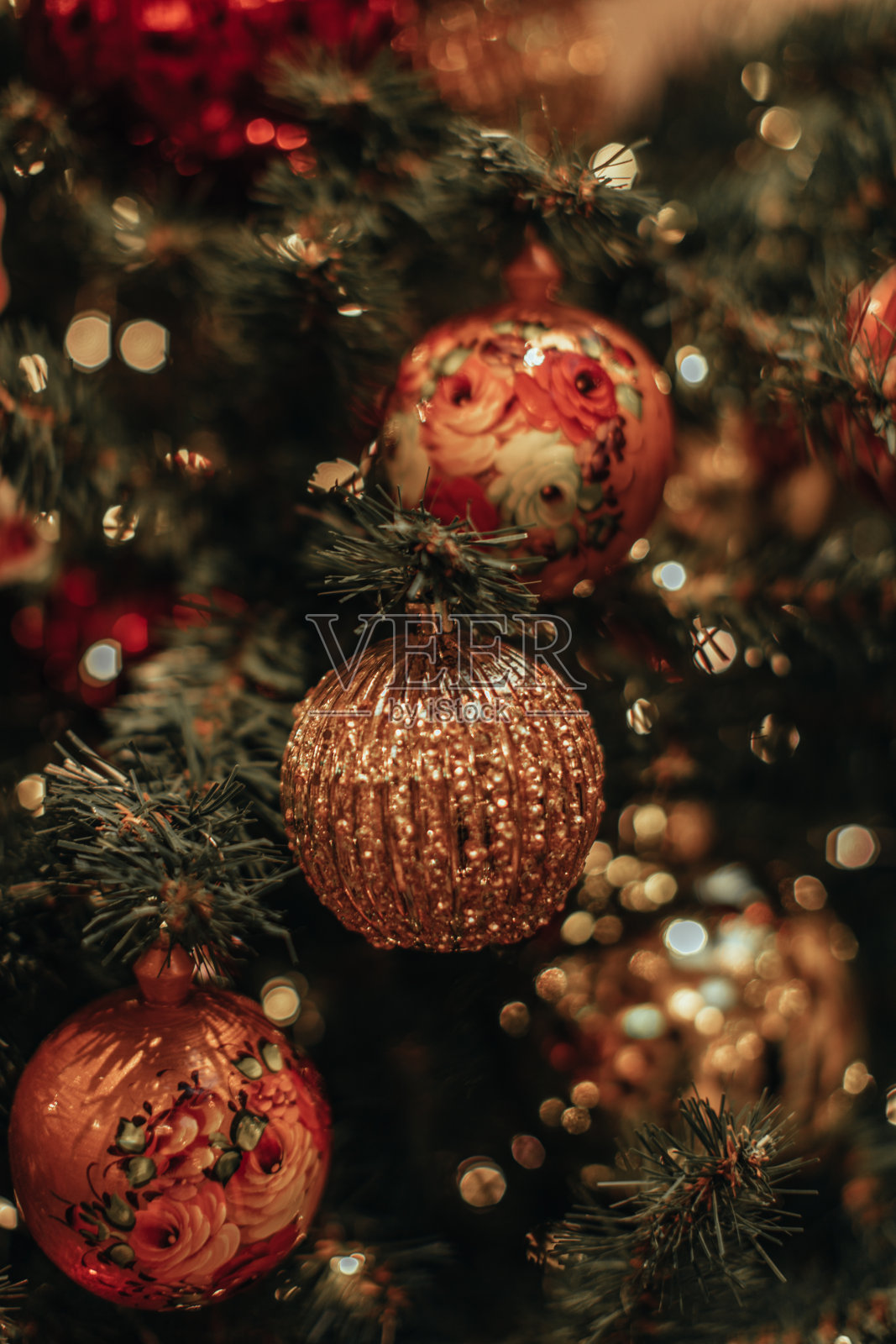 金色的圣诞球挂在圣诞树上的花环灯。照片摄影图片