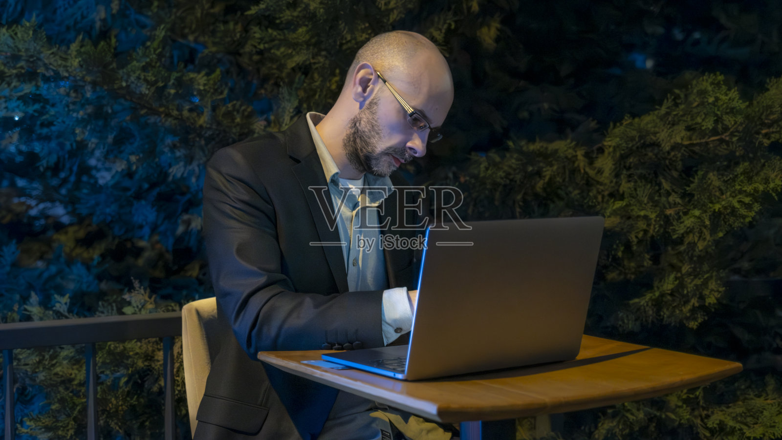 一位中年英俊的商人在办公室外用他的笔记本电脑工作照片摄影图片