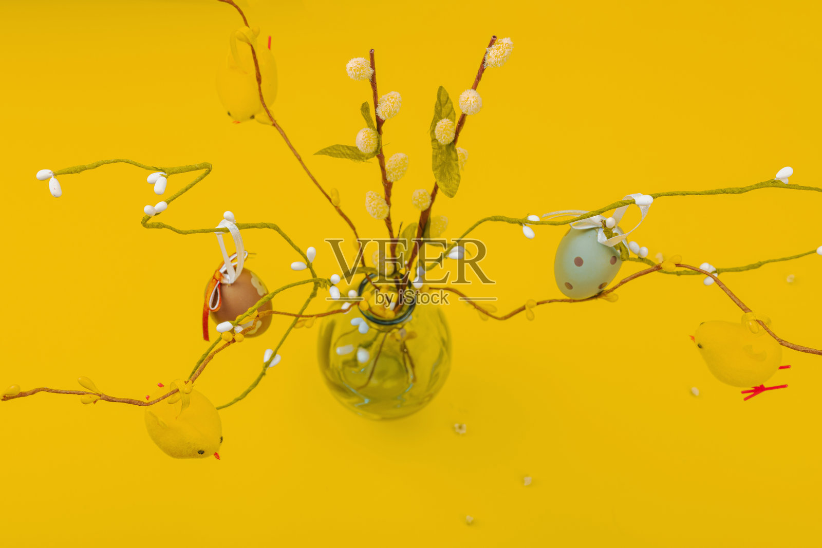 传统的复活节树组成与柳枝,手工蛋和鸟。明亮的黄色照片摄影图片