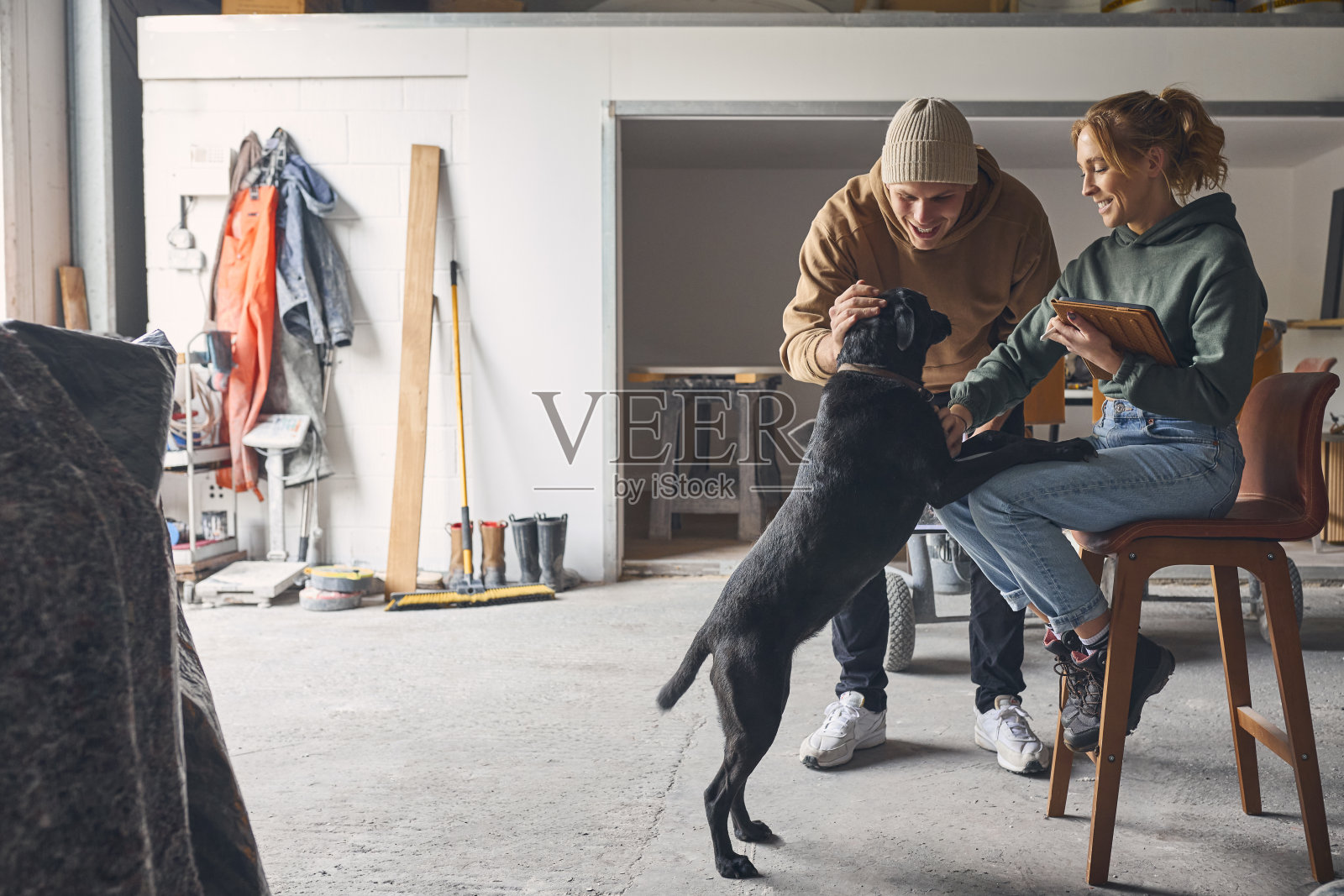 带着狗的男女工人在混凝土车间用数码平板电脑讨论文件照片摄影图片