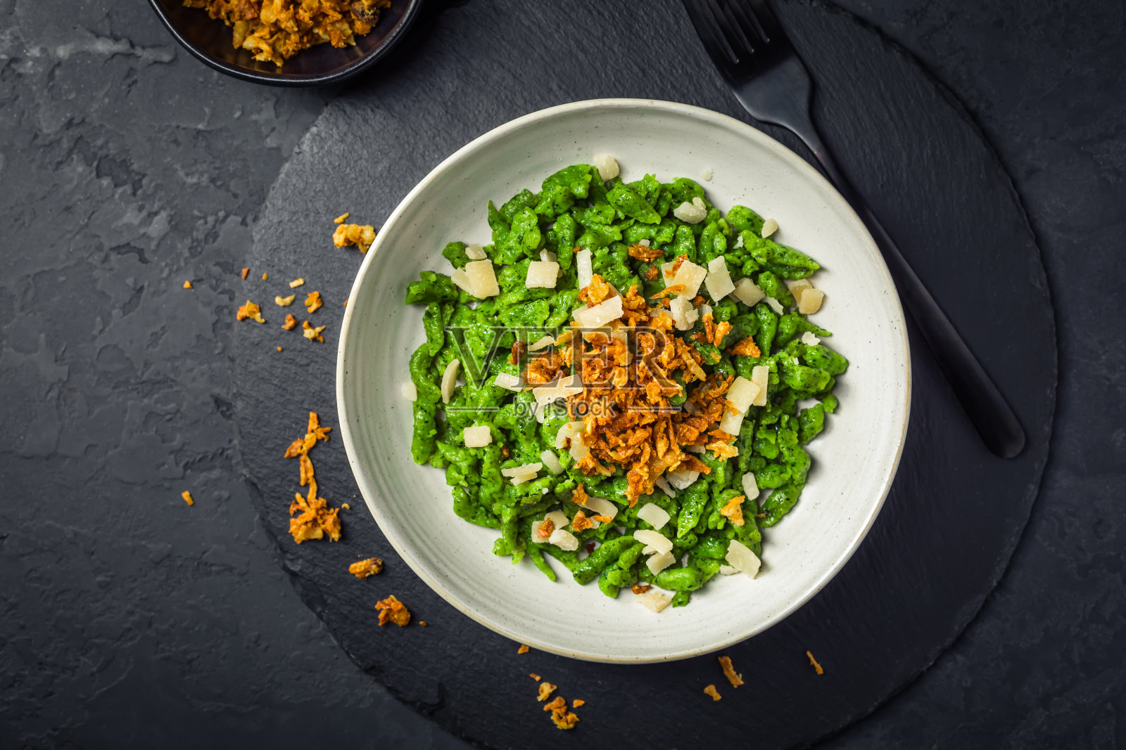 德国鸡蛋面——菠菜意式炒面配帕尔马干酪和烤洋葱照片摄影图片