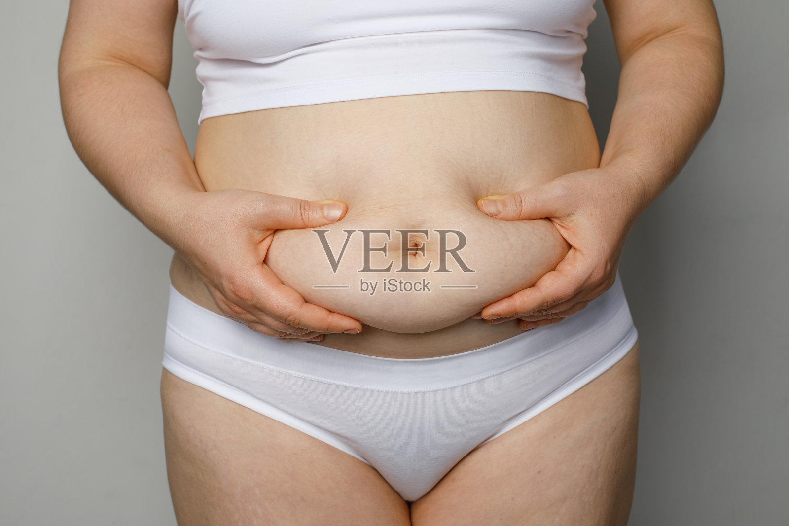 女人捂着自己的肚子照片摄影图片