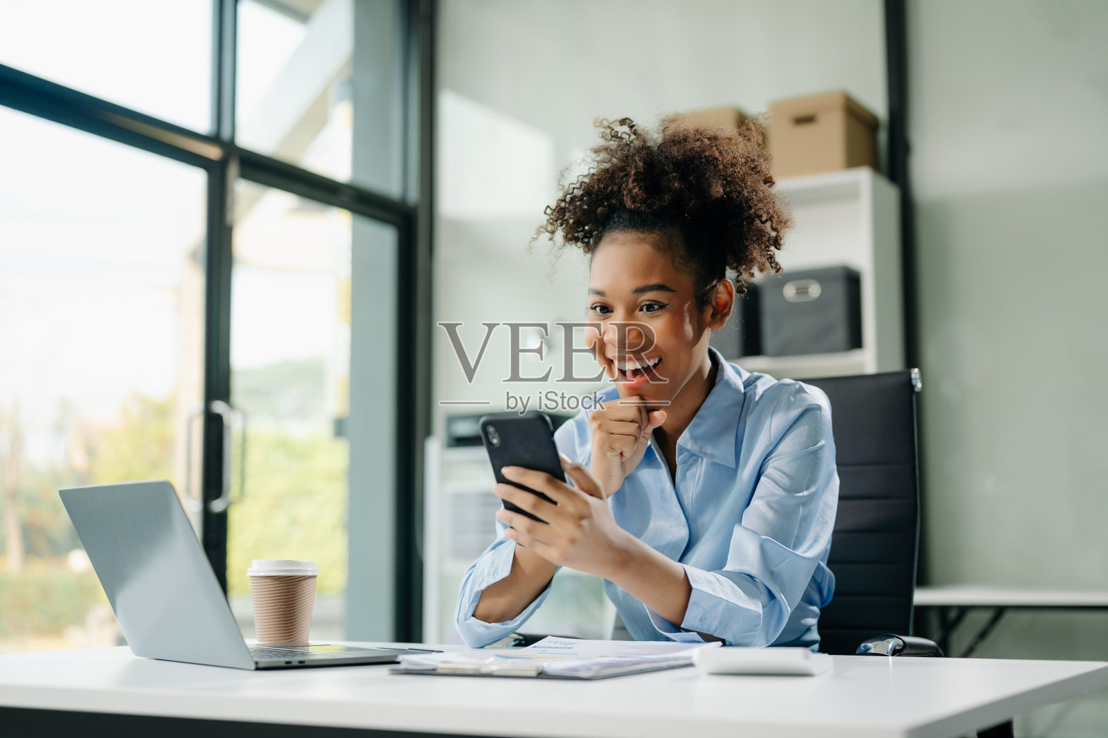 商务女性对她们在办公室用平板电脑、笔记本电脑和做笔记所做的工作感到高兴和快乐。照片摄影图片