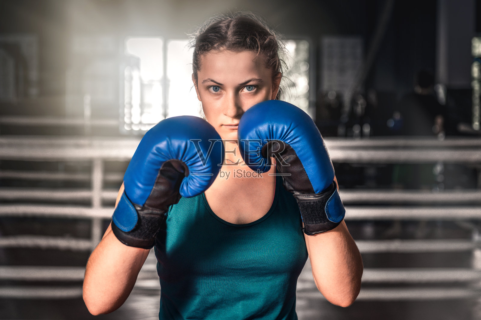 女孩戴着拳击手套在健身房训练的特写镜头。年轻女子在健身房拳击照片摄影图片