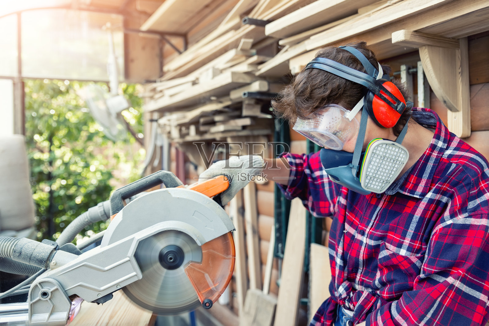 年轻漂亮手巧的专业快乐女强木工肖像戴着护目镜在木工diy车间用圆锯工作。自信的女性男性爱好在工作台上照片摄影图片