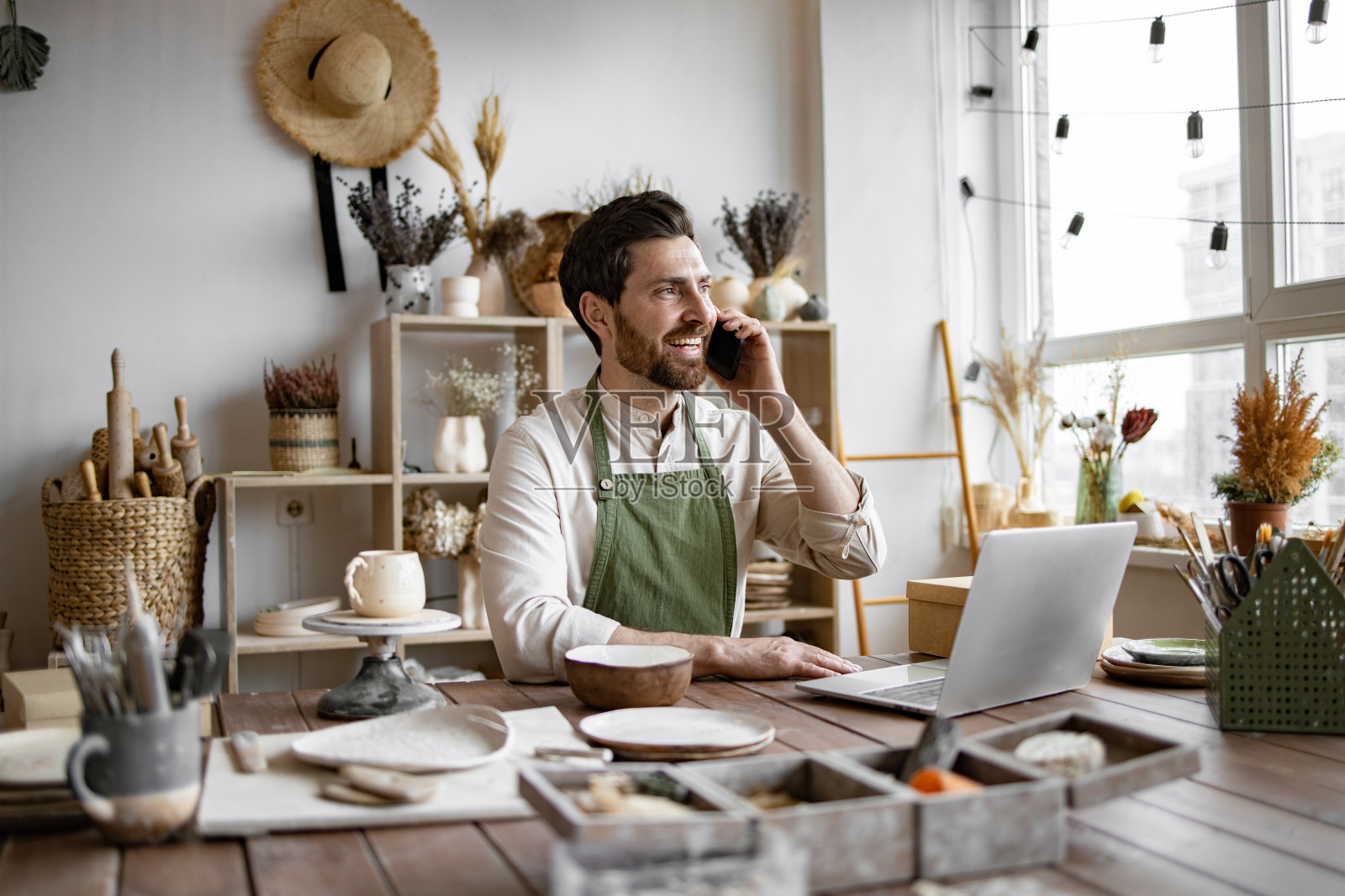 成功的商人粘土店老板与顾客交谈。照片摄影图片
