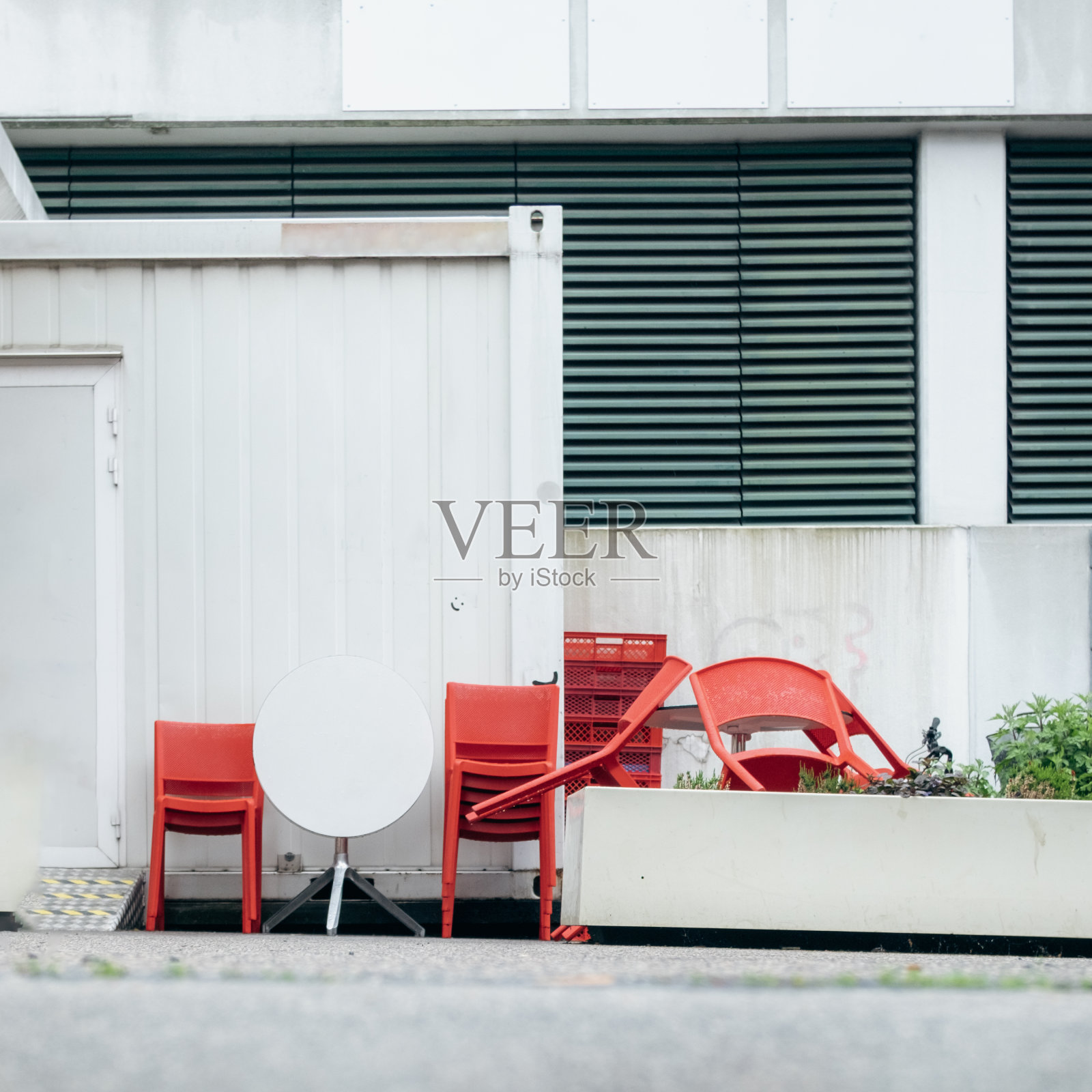 广场上有一家关门的咖啡馆,红色的小酒馆椅子照片摄影图片