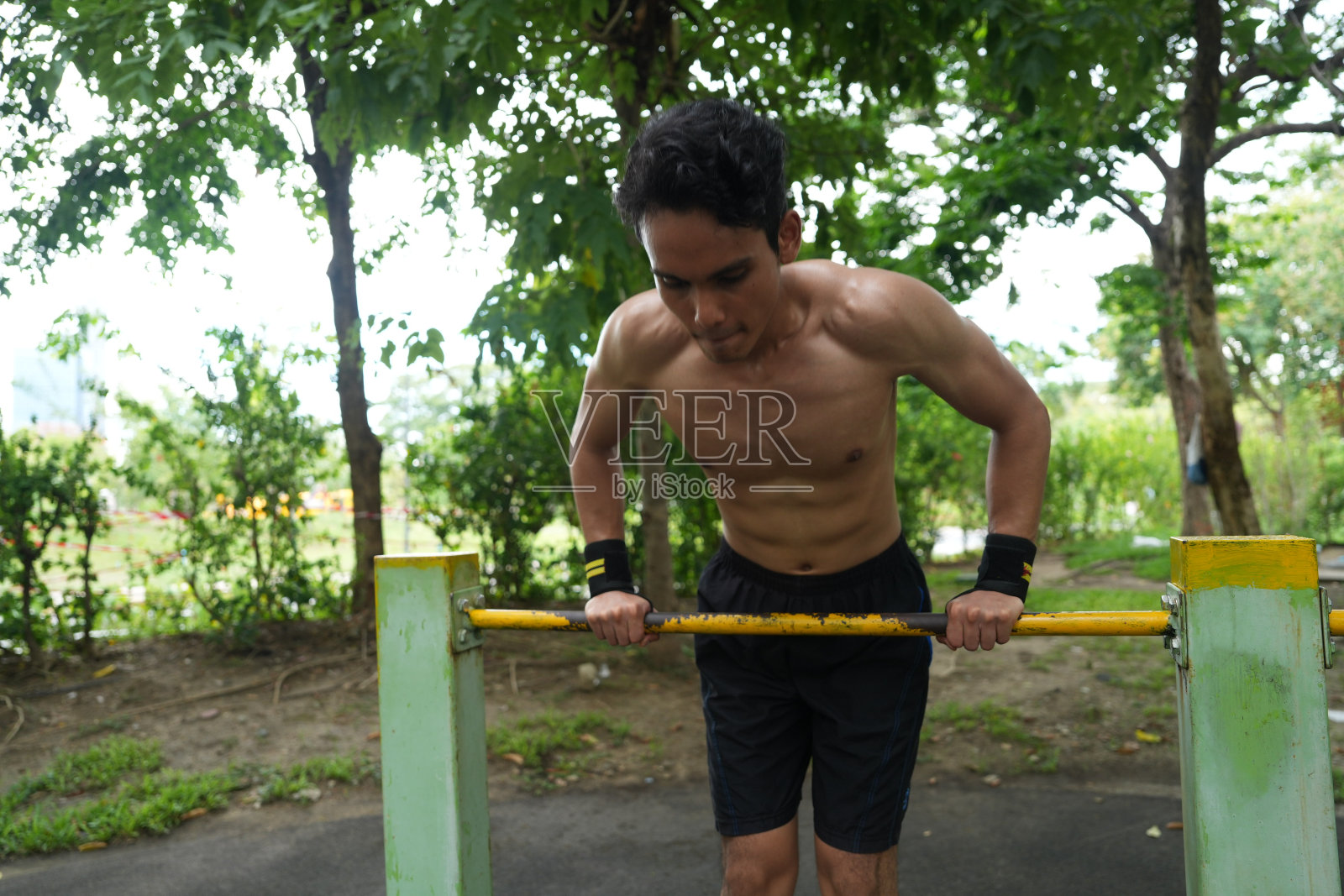 亚洲男子练习体操做体操杠和箍练习伸展和休息运动。照片摄影图片