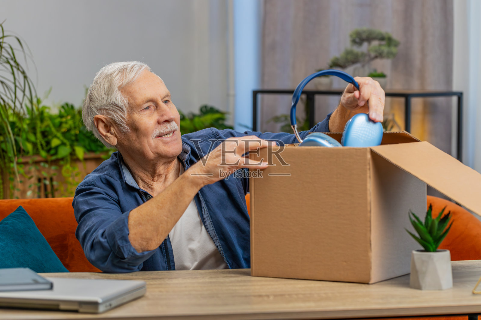 快乐的老人购物者打开耳机纸板箱送货包裹网购购买照片摄影图片