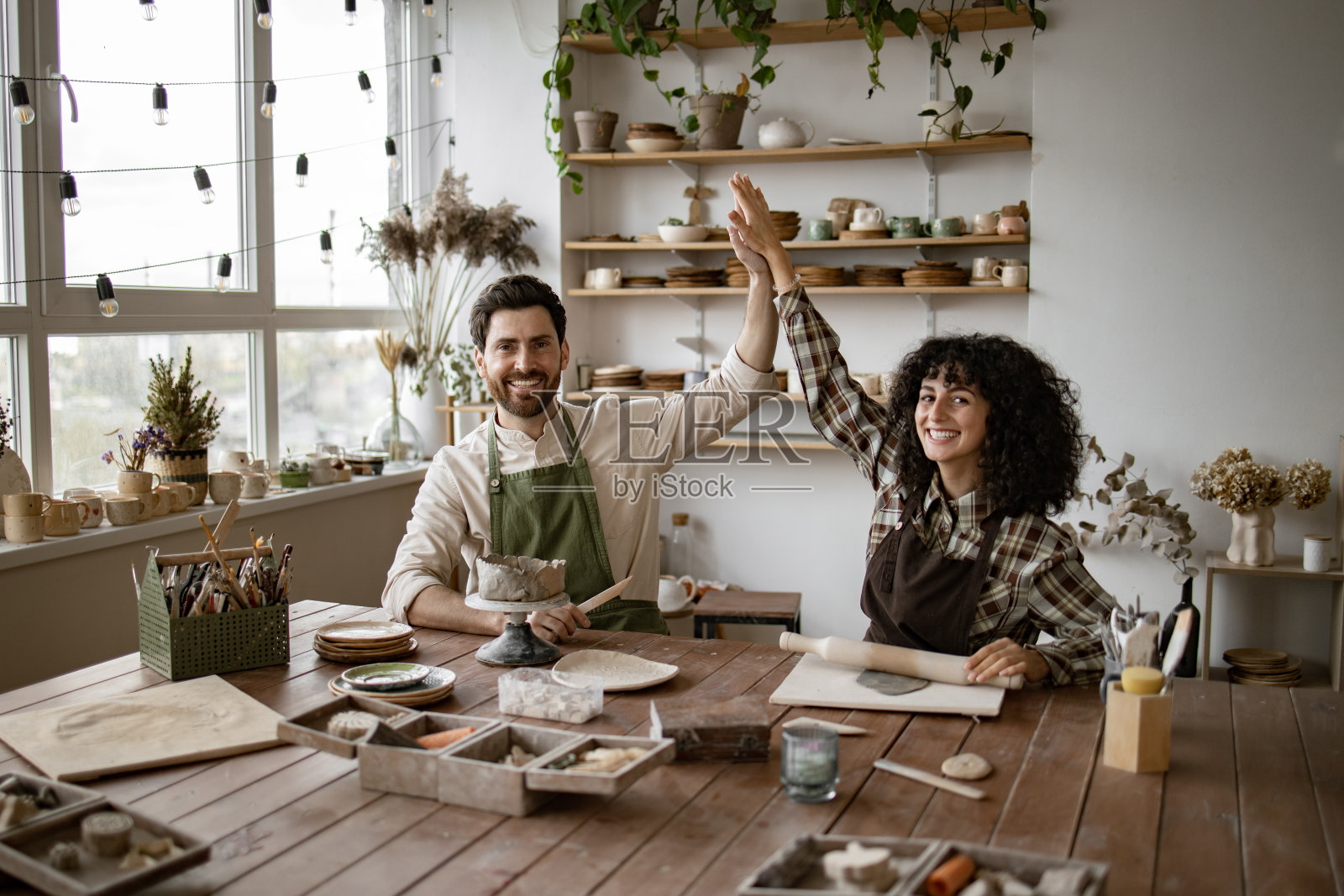 一男一女在工作室制作陶器时击掌照片摄影图片