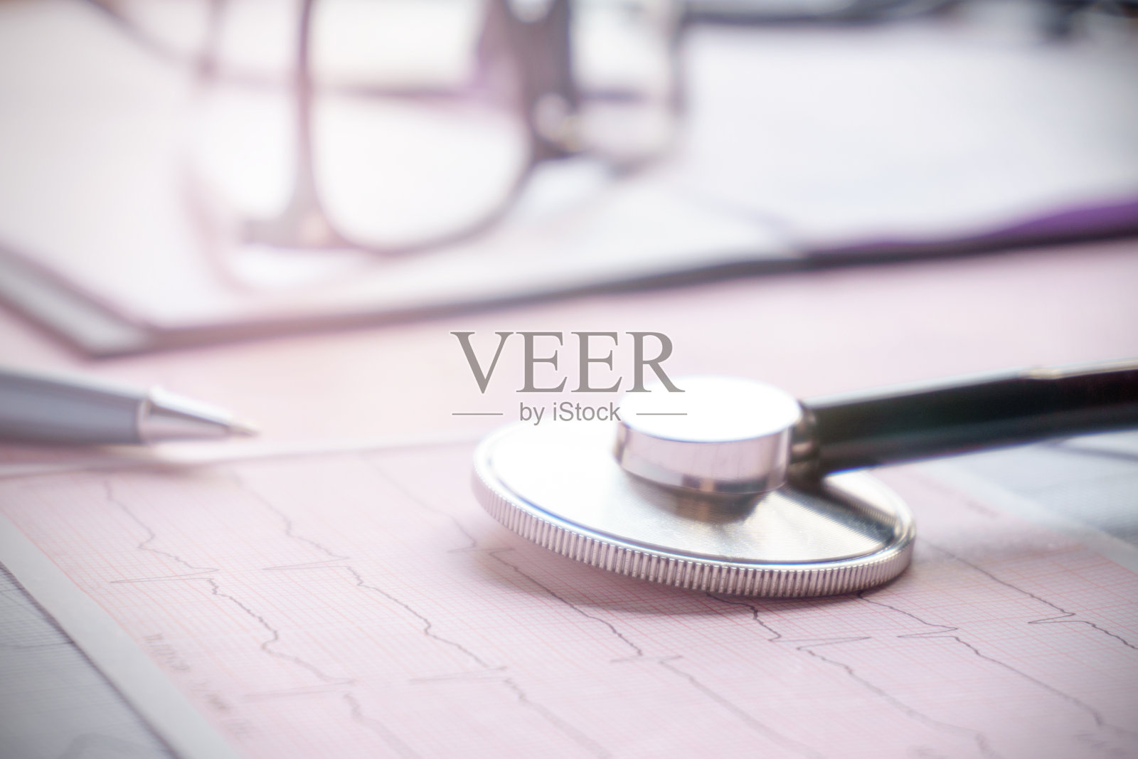 听诊器、眼镜和笔放在心电图上。医学的概念照片摄影图片