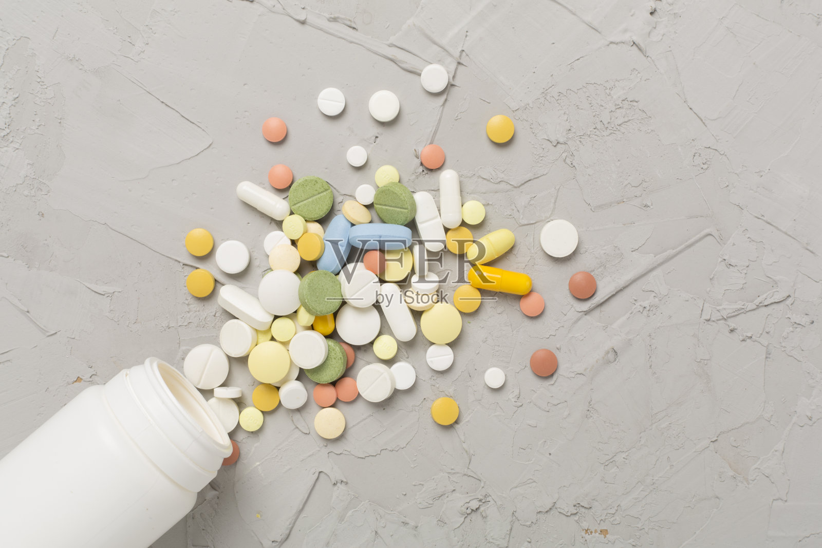混凝土背景上装有不同药物和胶囊的罐子,俯视图照片摄影图片