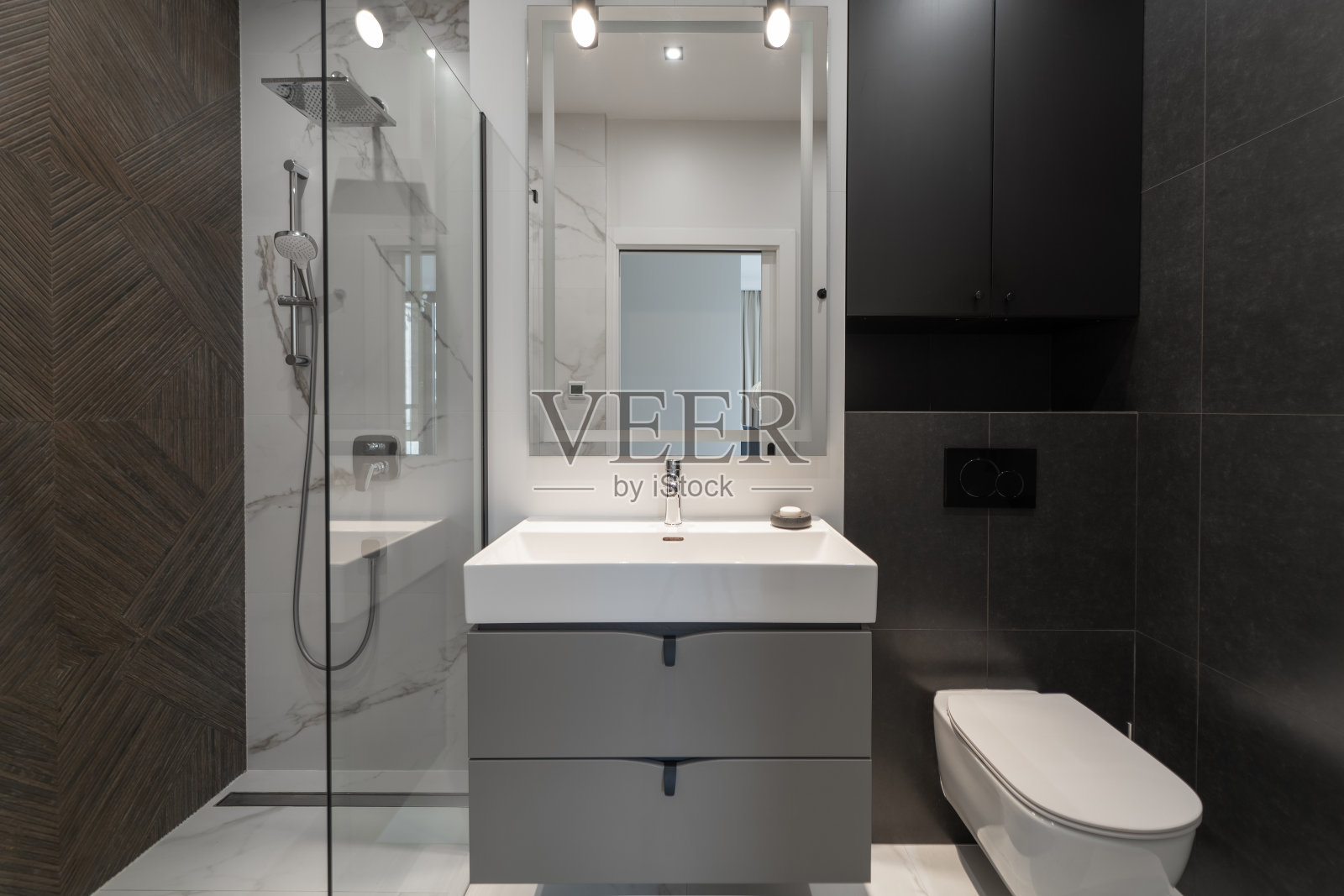 优雅的现代浴室,配有时尚的灯具和玻璃淋浴间照片摄影图片