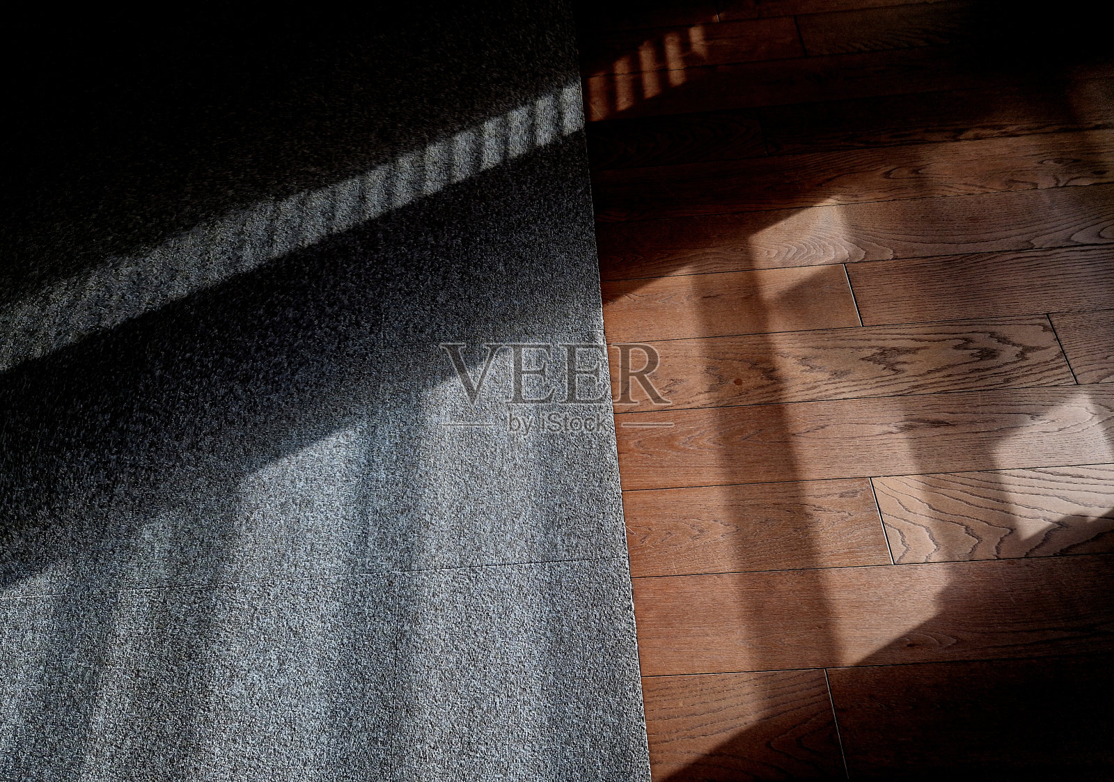 室内木地板和地毯的连接可能是个问题。这样地板就可以保持在相同的高度,地毯的边缘也不会磨损。斑驳的照片摄影图片