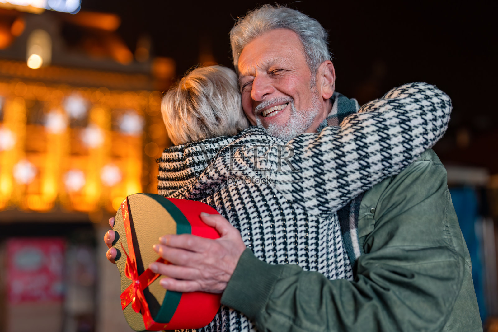 老人在街上收到一个女人的礼物,感到很高兴和被爱照片摄影图片