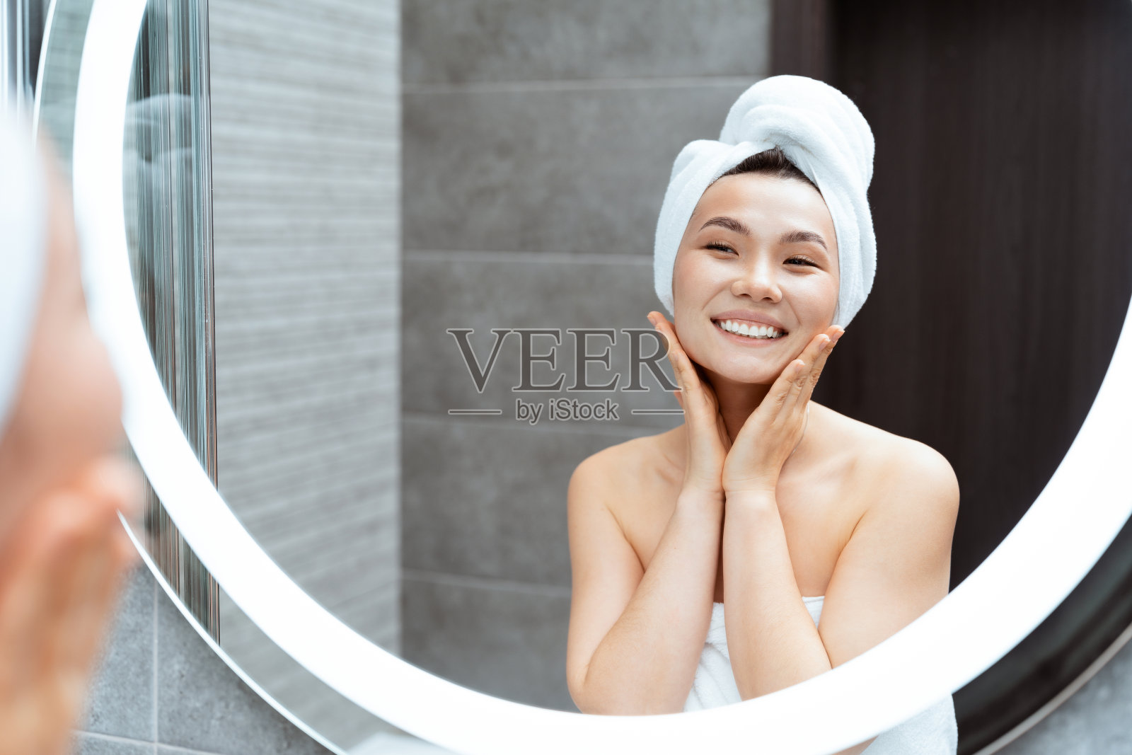 年轻女子在现代浴室享受护肤程序照片摄影图片