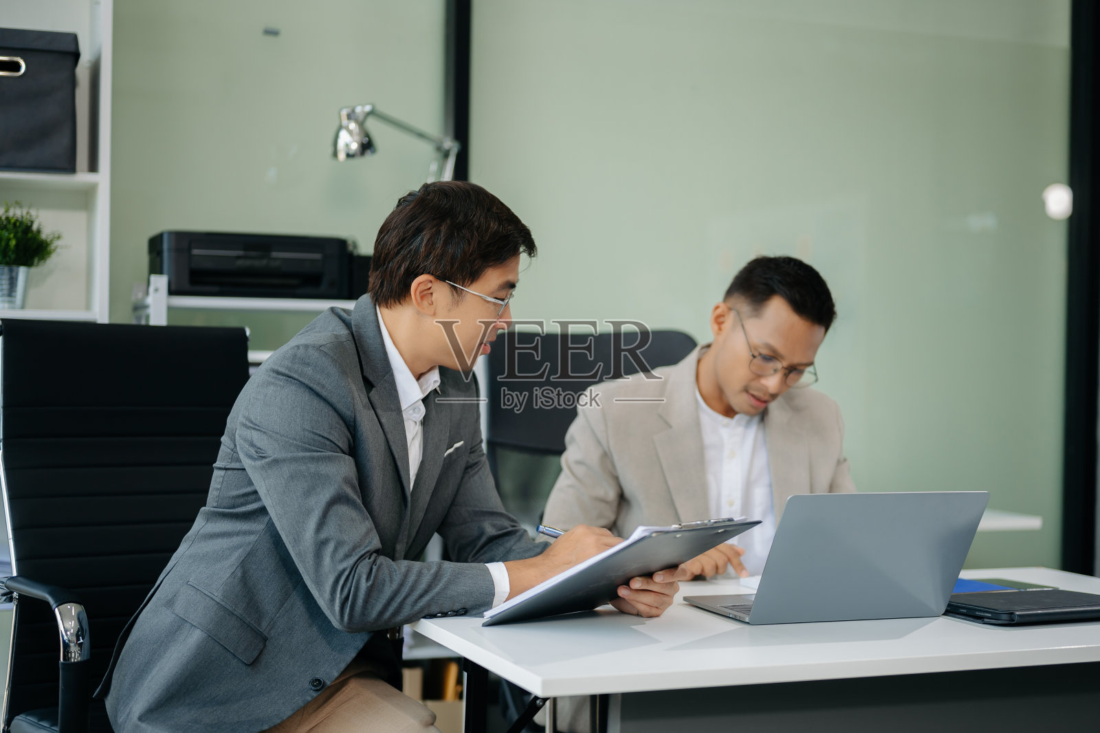 快乐的亚洲商人在合作一个新项目。使用笔记本电脑和平板电脑照片摄影图片