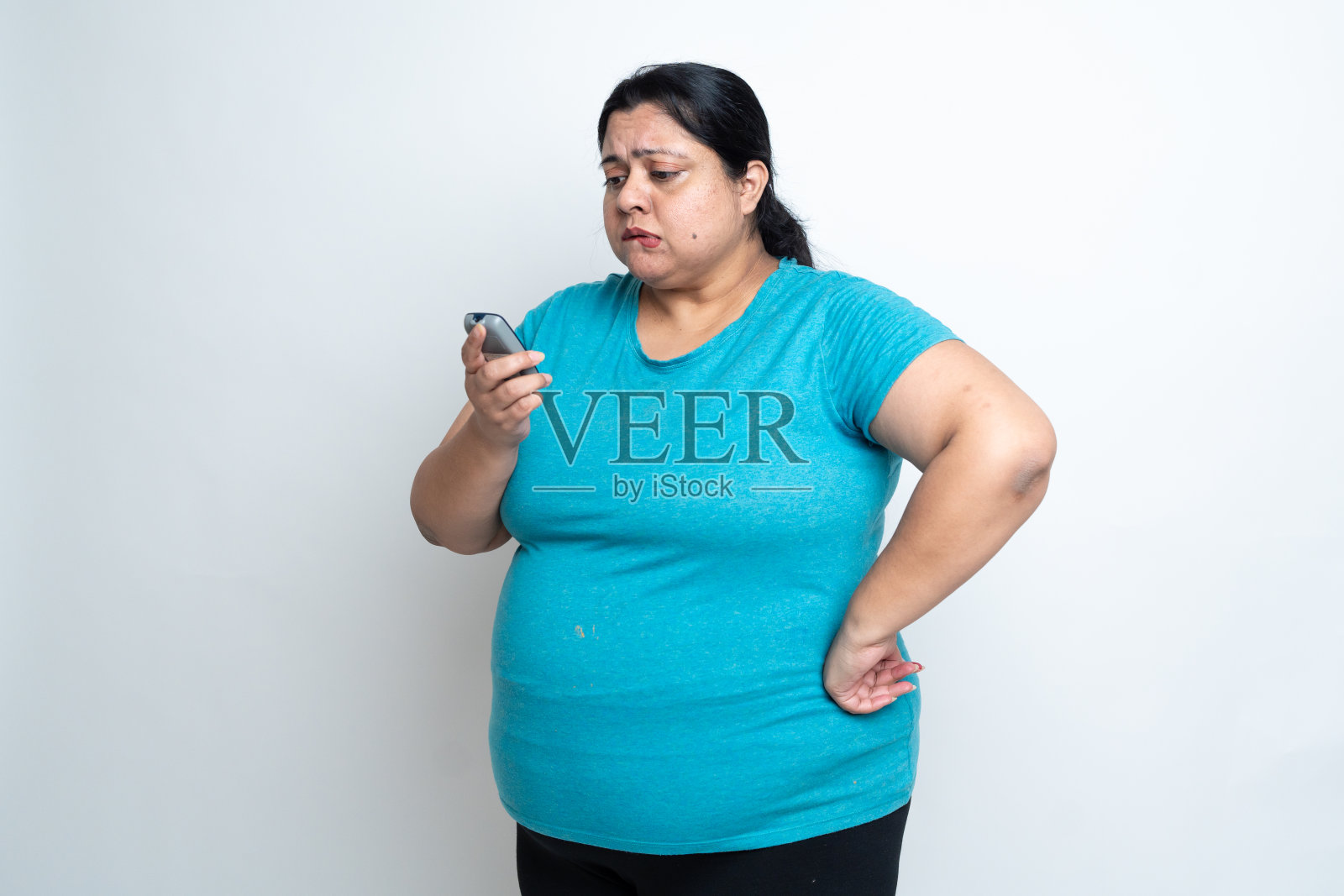 超重肥胖的印度妇女用血糖仪检查或测试血糖,隔离在白色背景上。加码女性。医疗保健的概念。本空间照片摄影图片