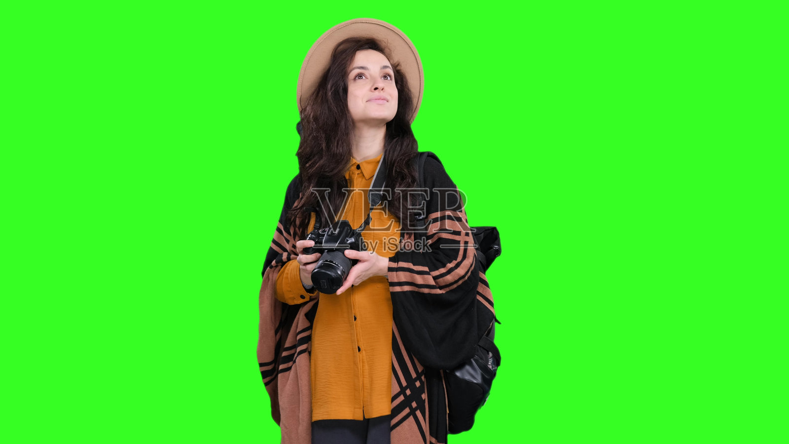 微笑的女人拿着相机和背包在色度键上摆姿势照片摄影图片