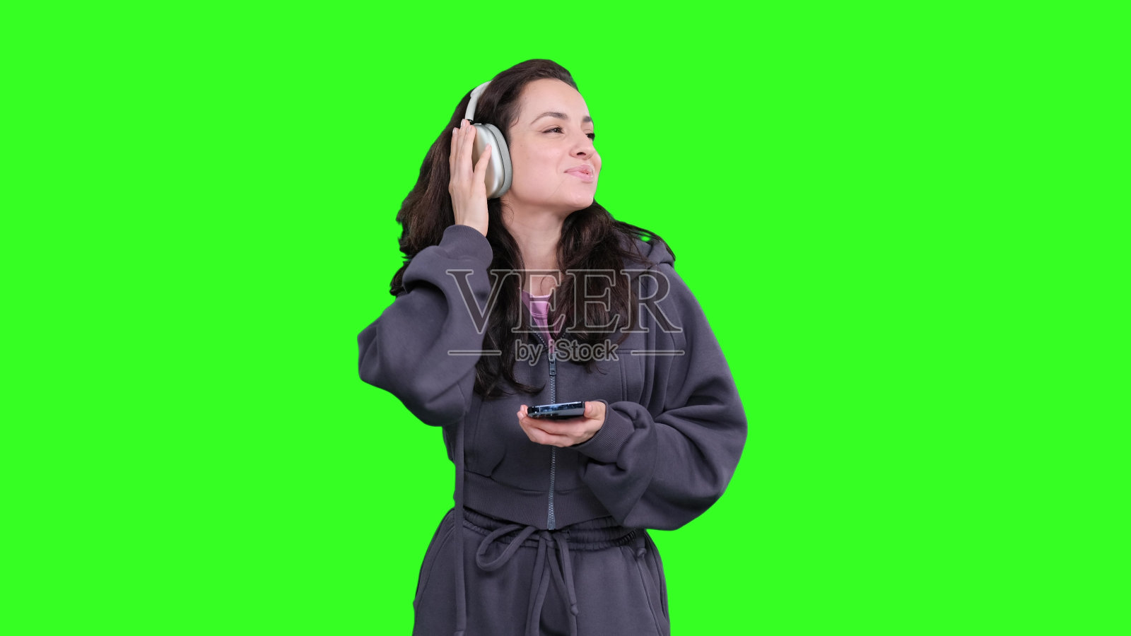 快乐的女人在跳舞,戴着耳机听着音阶上的音乐照片摄影图片