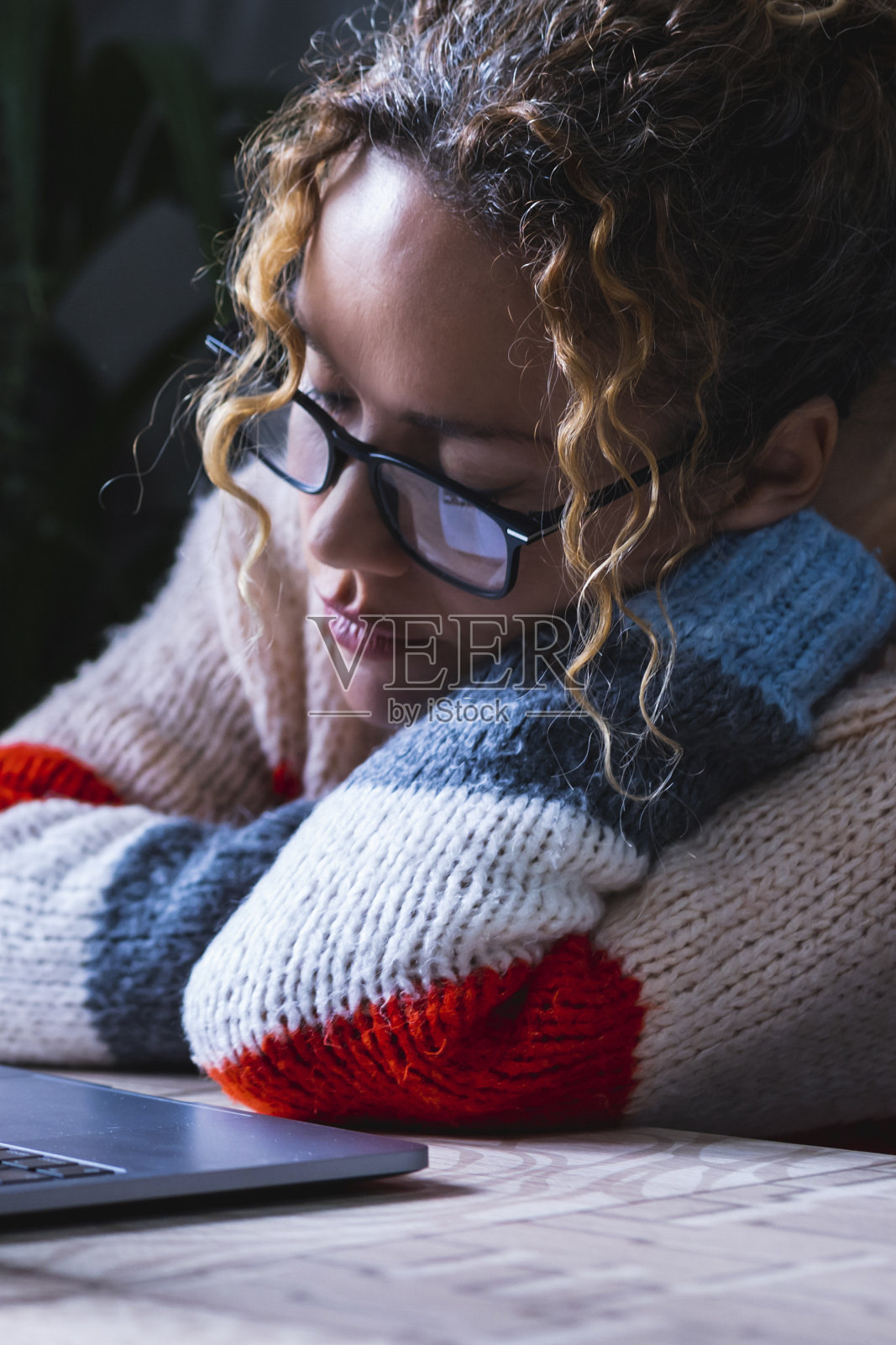 疲惫的女人在办公室用电脑睡觉。疲惫的企业家在笔记本电脑前睡觉。过度工作的概念。悲伤和沮丧。孤独。独自在家的女士照片摄影图片
