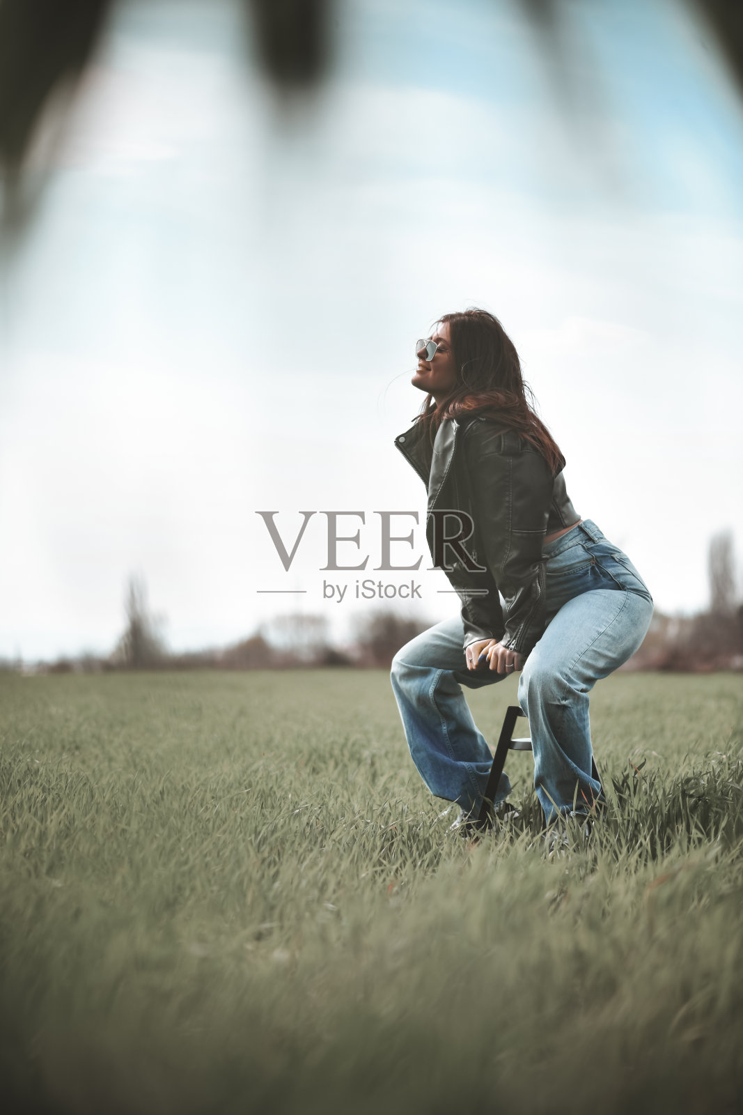 女性在草地上以色利前进党凝视,坐在椅子上照片摄影图片