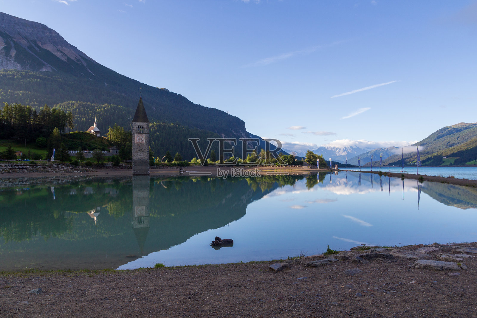 意大利南蒂罗尔,瑞申湖和阿尔卑斯山脉的全景图与淹没教堂的尖塔(钟楼)照片摄影图片