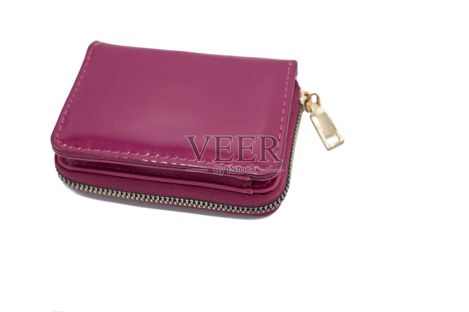 白色背景的女人钱包。这是一个亮粉色的钱包,上面有金色的拉链照片摄影图片