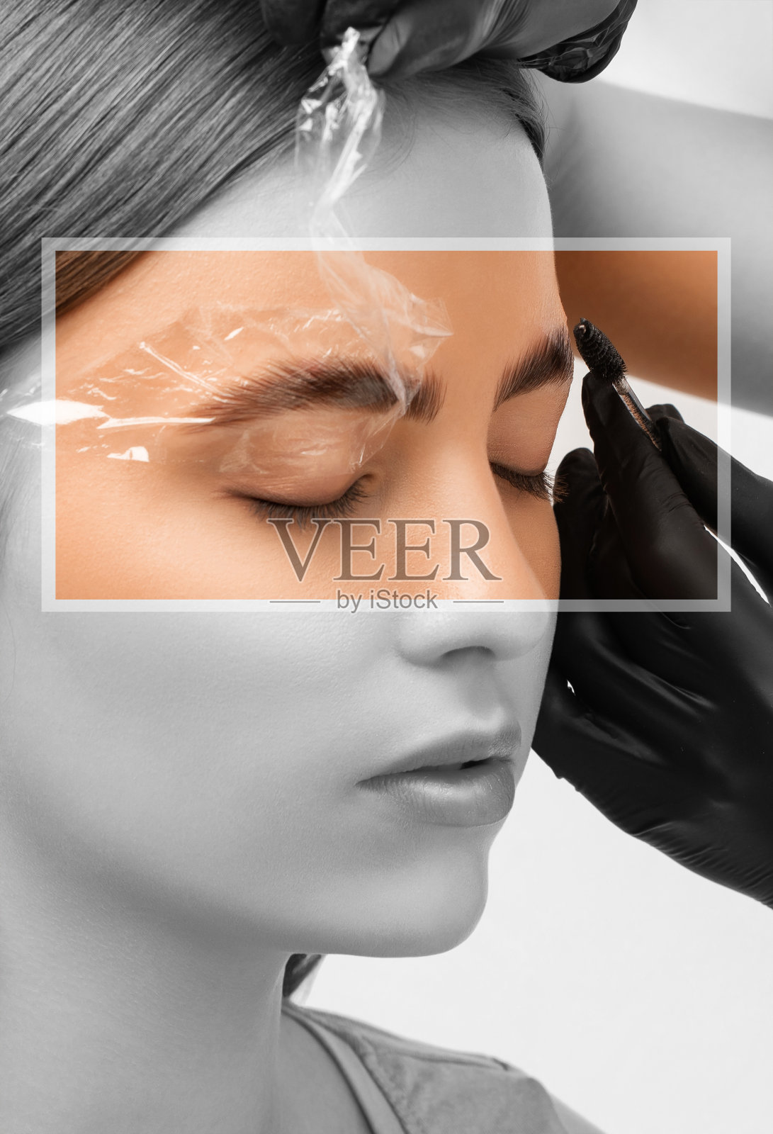 化妆师会给眉毛做持久造型,还会给眉毛上色。眉毛纹理。专业的化妆和面部护理。照片摄影图片