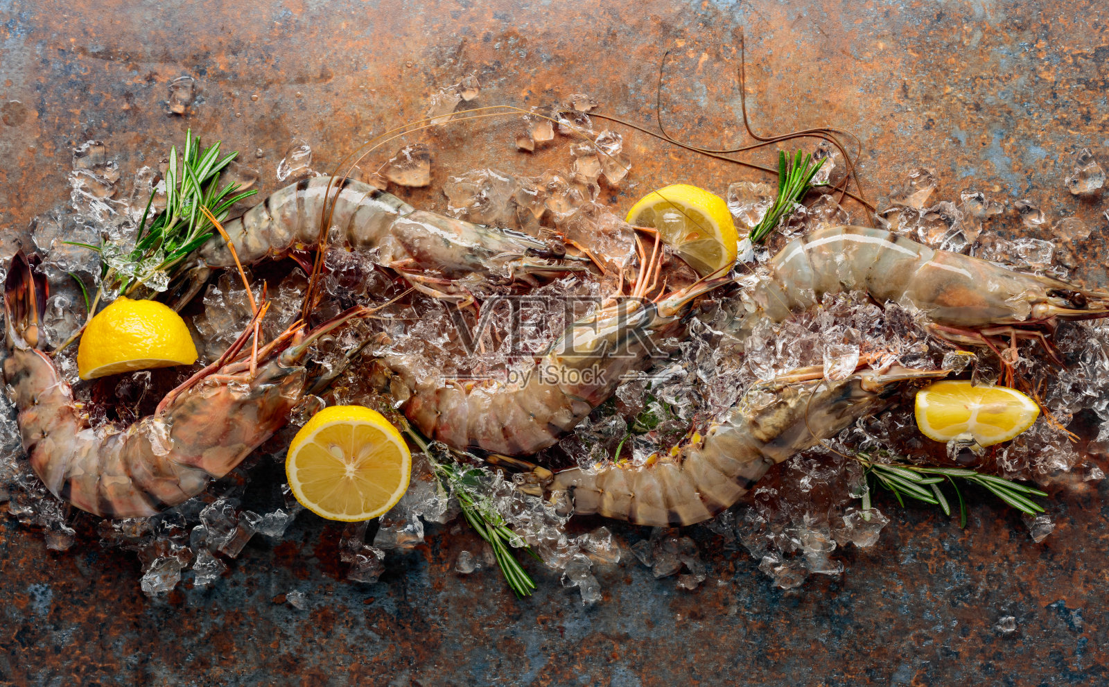 鲜虎虾配柠檬和迷迭香。照片摄影图片