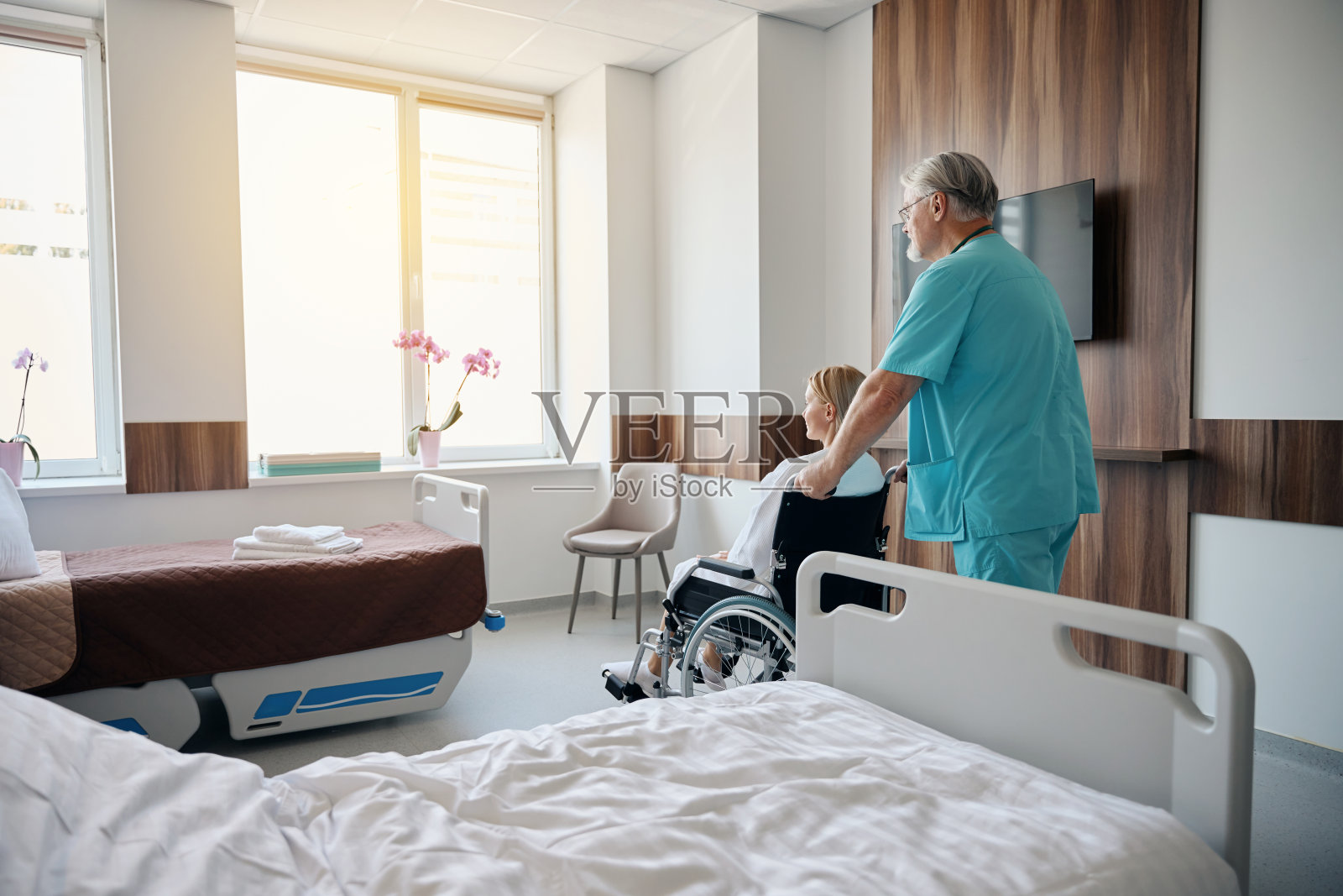 临床医生在查房时用轮椅运送残疾病人照片摄影图片